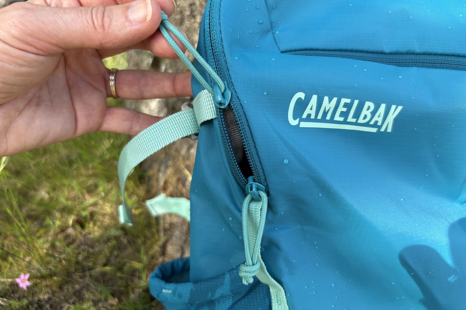 A woman shows a close-up of the zippers on her pack