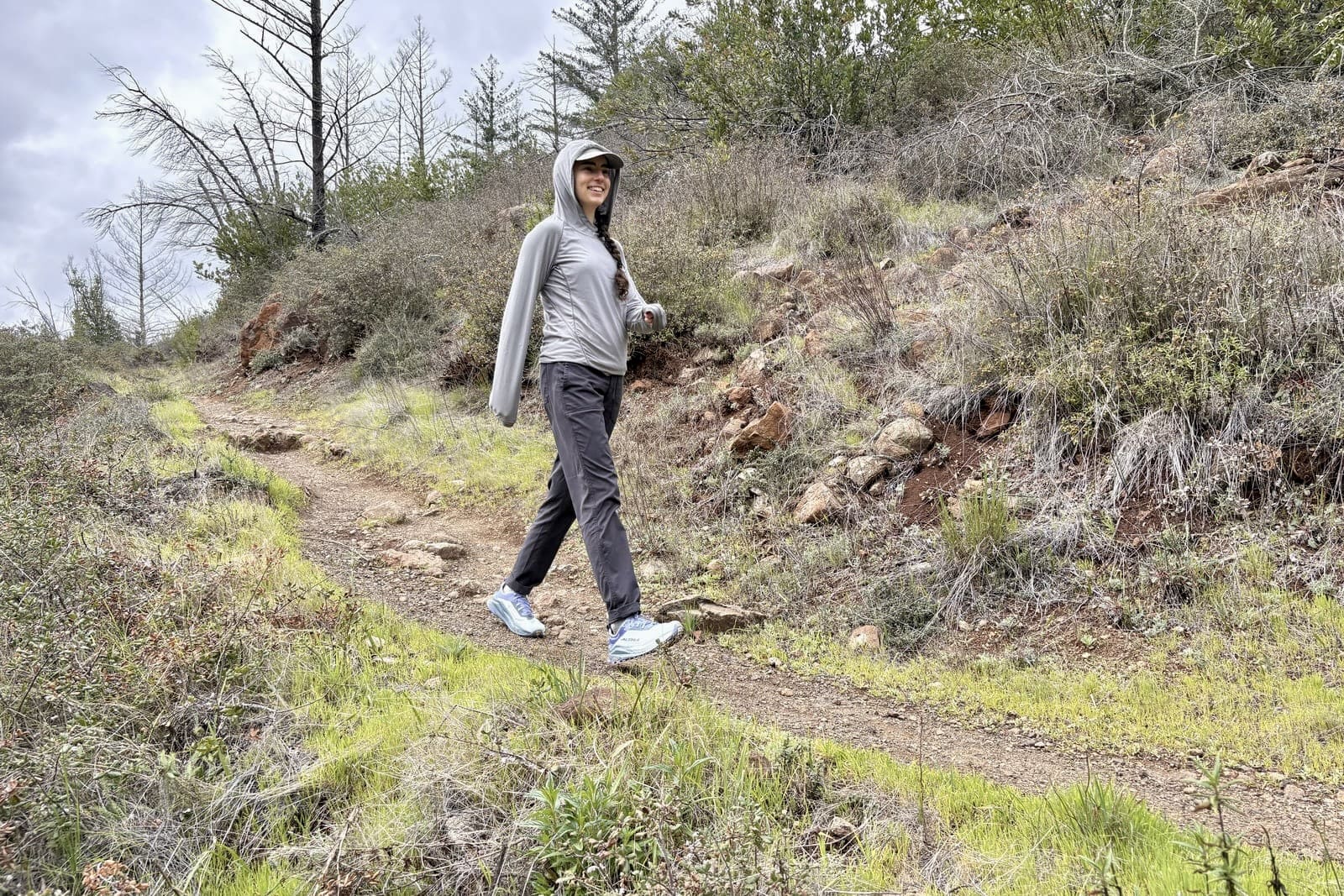 A woman walks along a trail in her Altras.