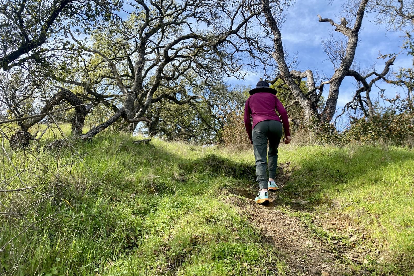 A woman hikes up a steep hill.