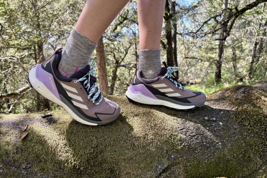 Closeup of hiking shoes while standing on a log.