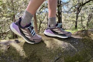 Closeup of hiking shoes while standing on a log.
