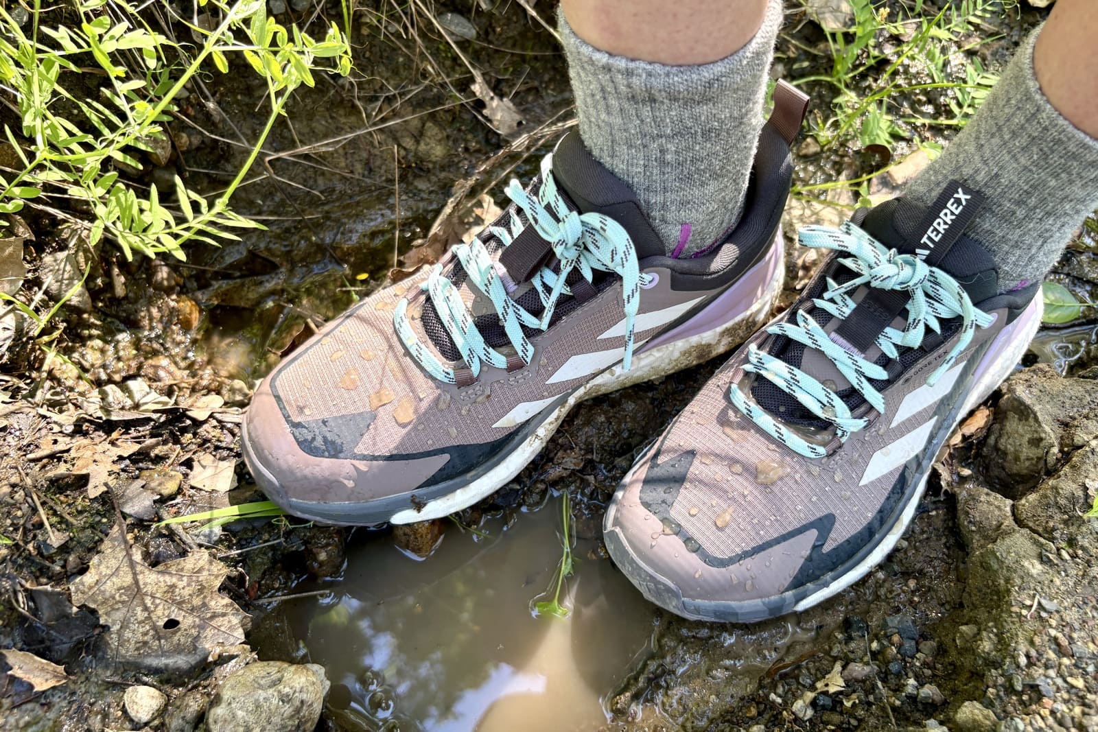 Closeup showing water beading off a woman’s hiking shoes.