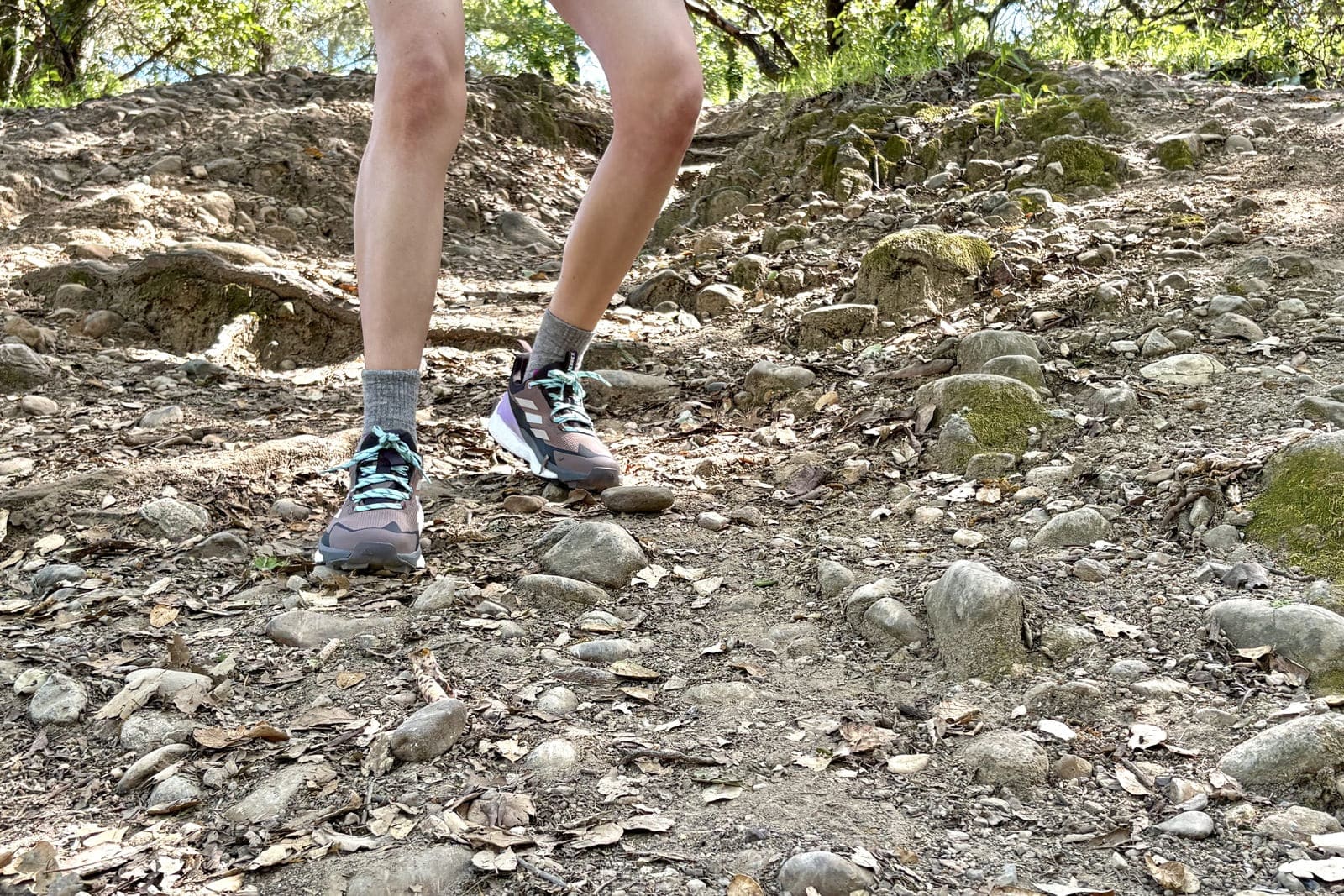 A woman hikes down a steep slope in her hiking shoes.