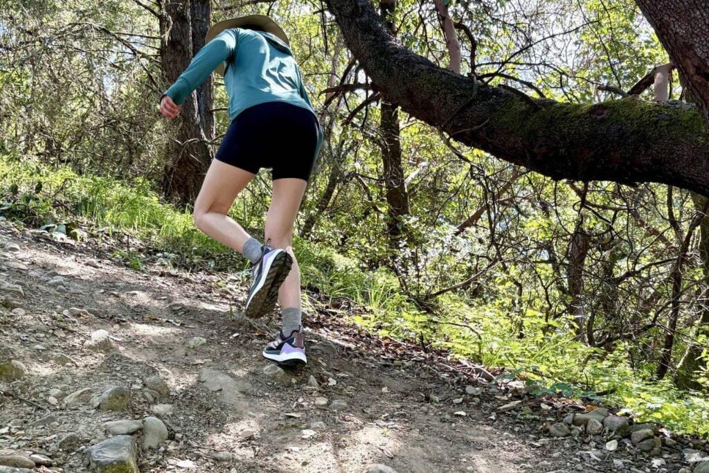 A woman hikes up a steep slope.