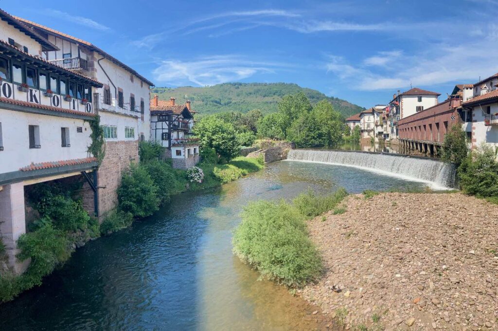 a picturesque spanish village with a waterfall flowing into a small river