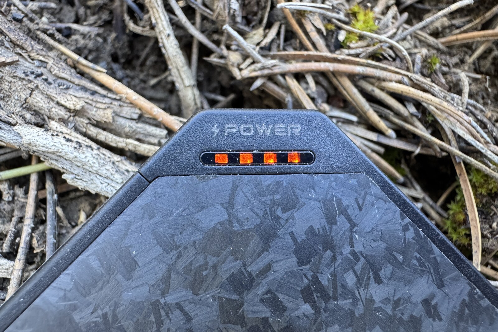Close up of the Flextail charge indicator with pine needles in the background.