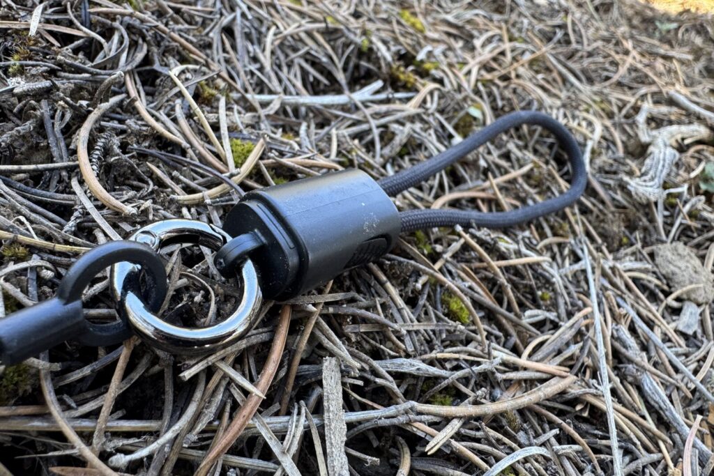 Close up of the 2-in-1 lanyard that comes with the Flextail power bank. It is sitting on some pine needles.