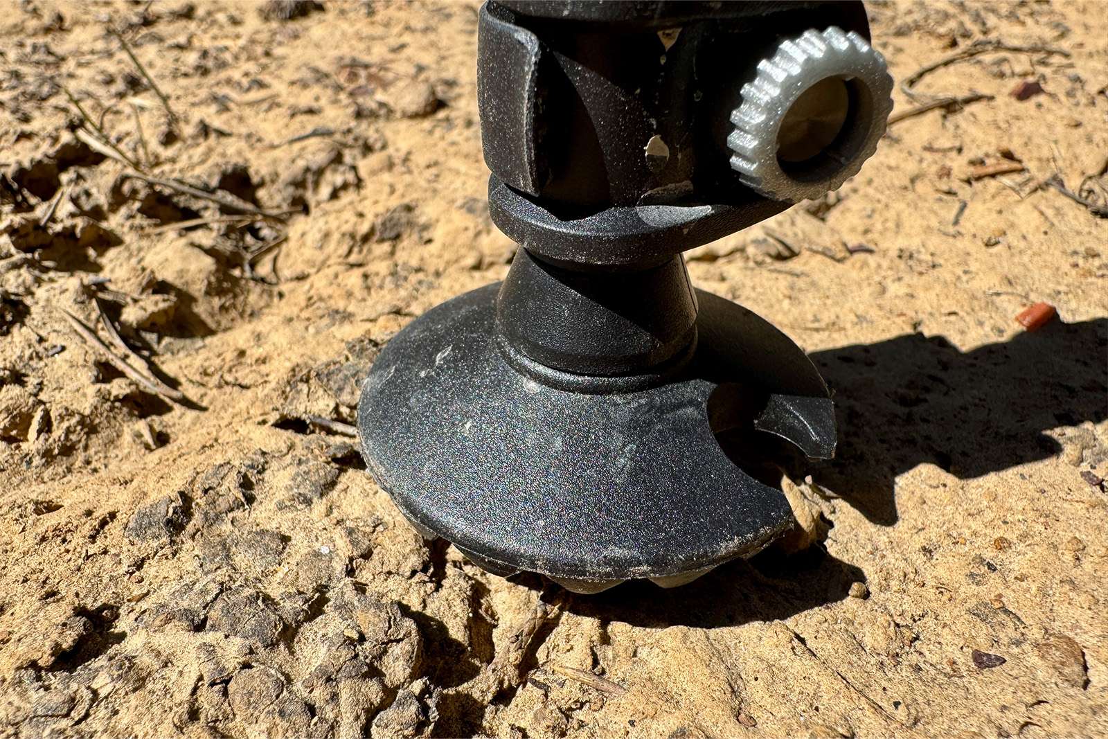 Close up of the summer basket on the Legacy pole as it is stuck in the ground. The ground is just dirt.