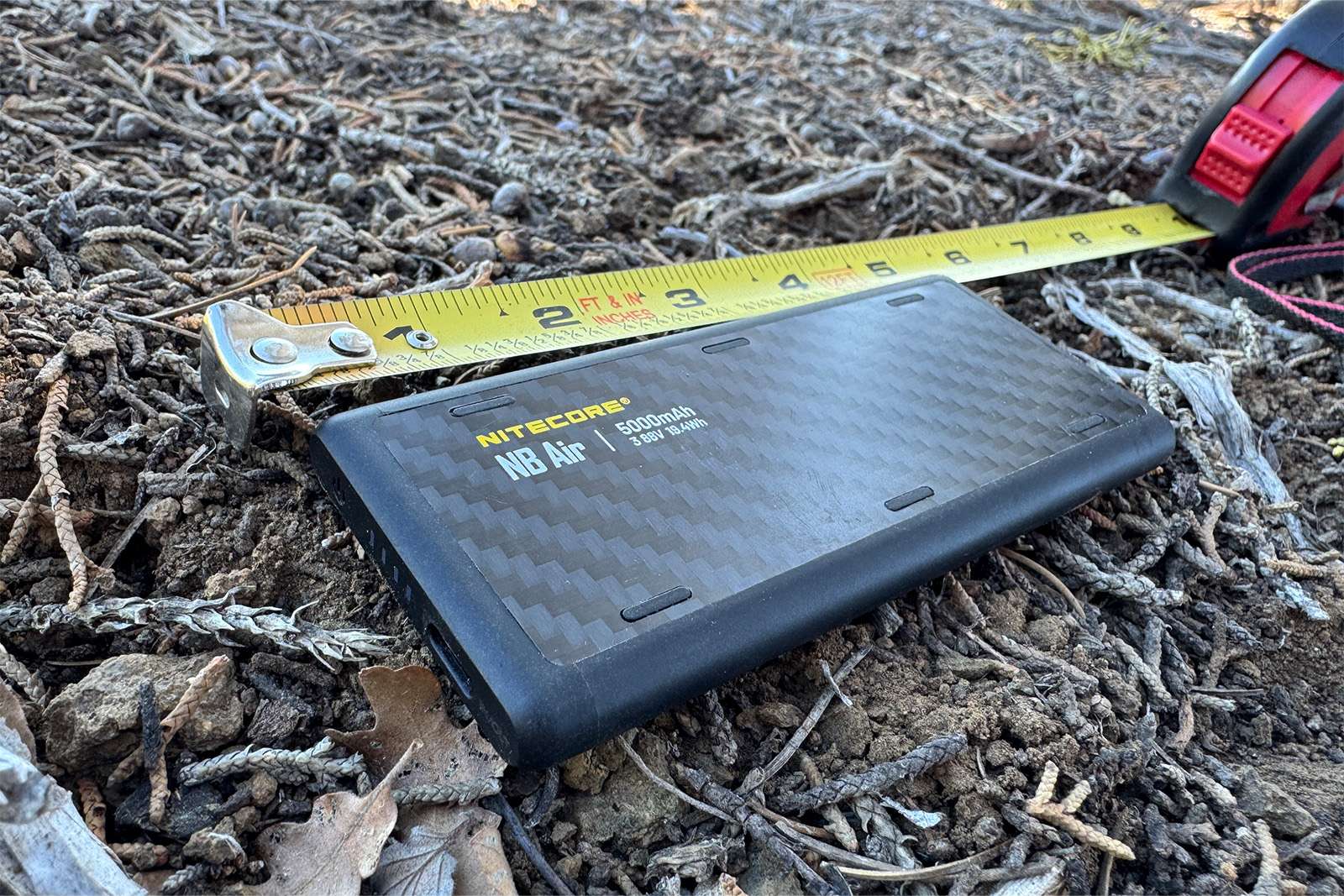 A closeup of the NB Air sitting on the ground with a measuring tape extended next to it.