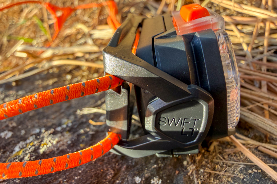 Side profile of the Petzl Swift headlamp showing the compact housing and “SWIFT” branding where the cord band attaches.