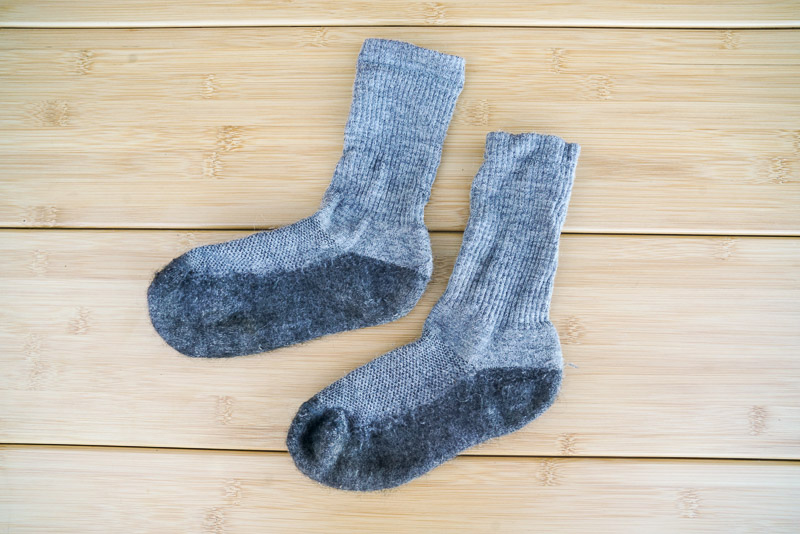 A close up image of a pair of grey socks sitting on a table.