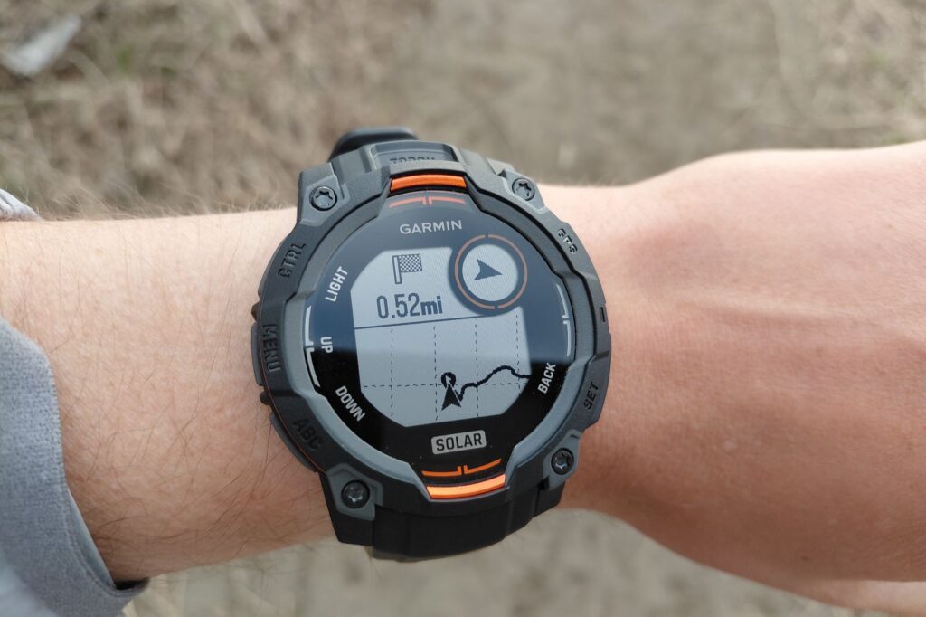 A black Garmin solar-powered smartwatch displays a navigation screen showing 0.52 miles walked.