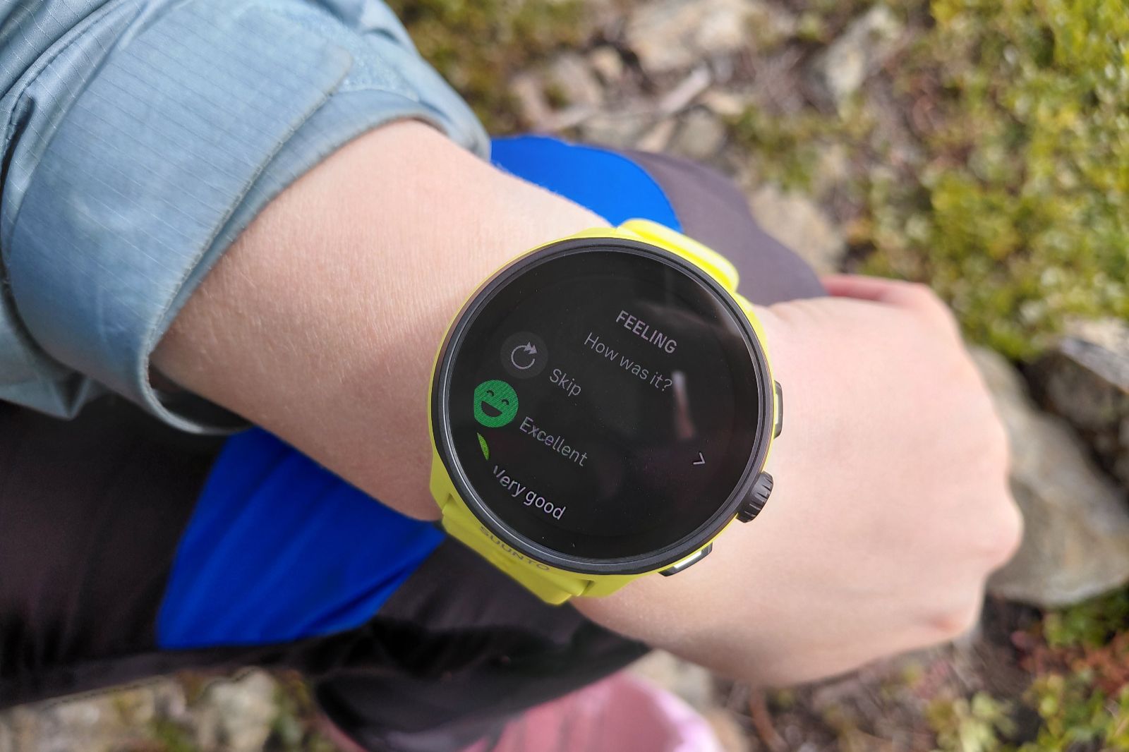 A close-up of a person’s wrist wearing a yellow smartwatch displaying a feedback screen.