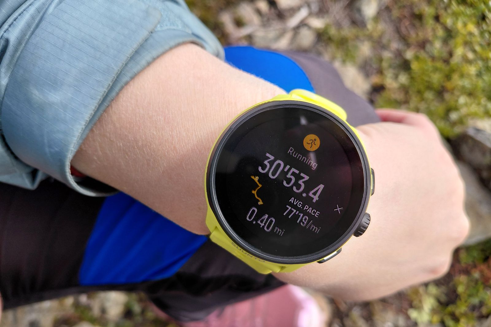 A wrist wearing a smartwatch displaying a running app.