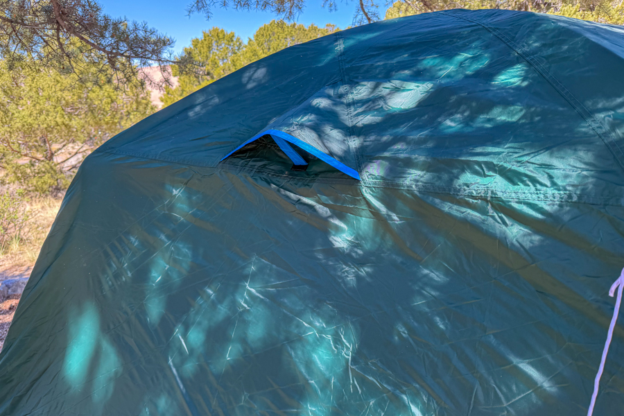 Close-up of one of the Coleman Skydome 4 tent's fly vents propped open on the rainfly exterior.