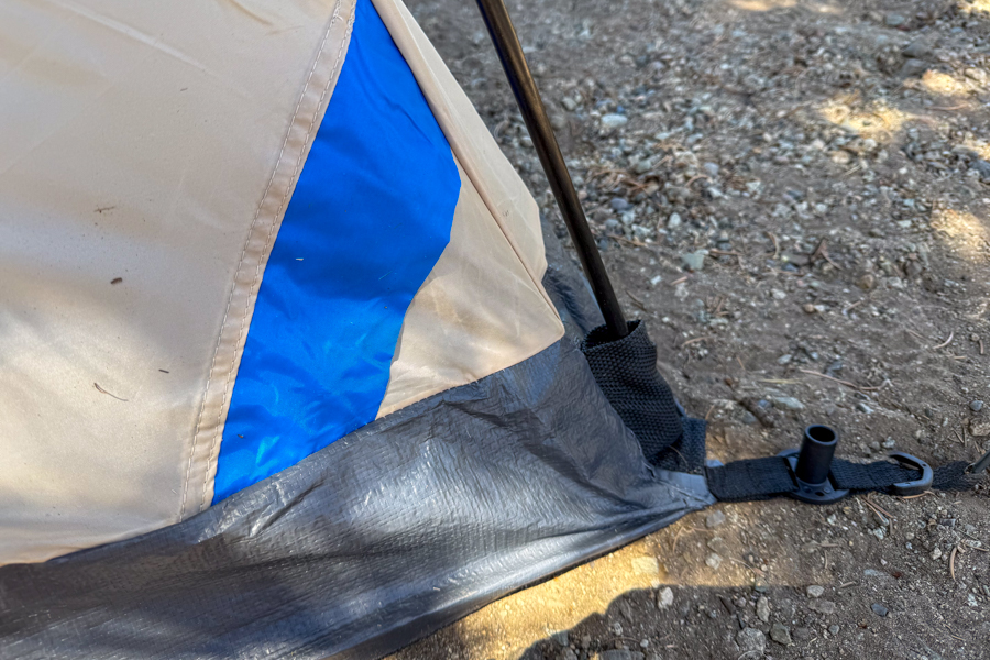 Close-up image of the Coleman Skydome 4 tent's corner showing the integrated pole connection and stake-out point at the base of the tent.