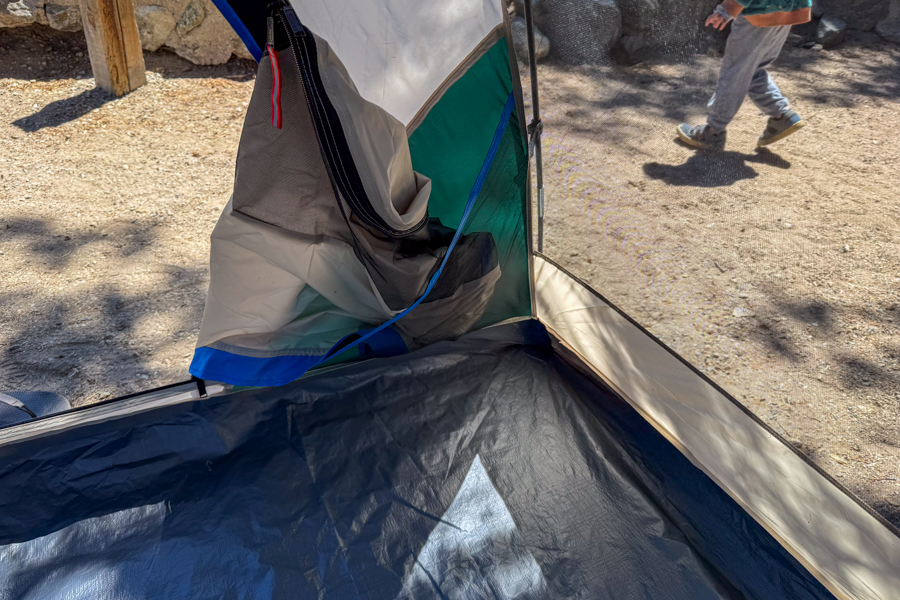 Close-up image of the interior corner of the Coleman Skydome 4 tent showing the wide door panel and lower wall construction from inside the tent.