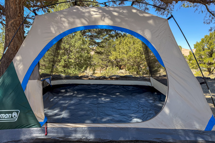 Front opening of the Coleman Skydome 4 tent body pitched without the rainfly, showing the large doorway and open mesh walls.