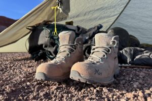 The TX Hike boots sitting in front of a backpack and tent.