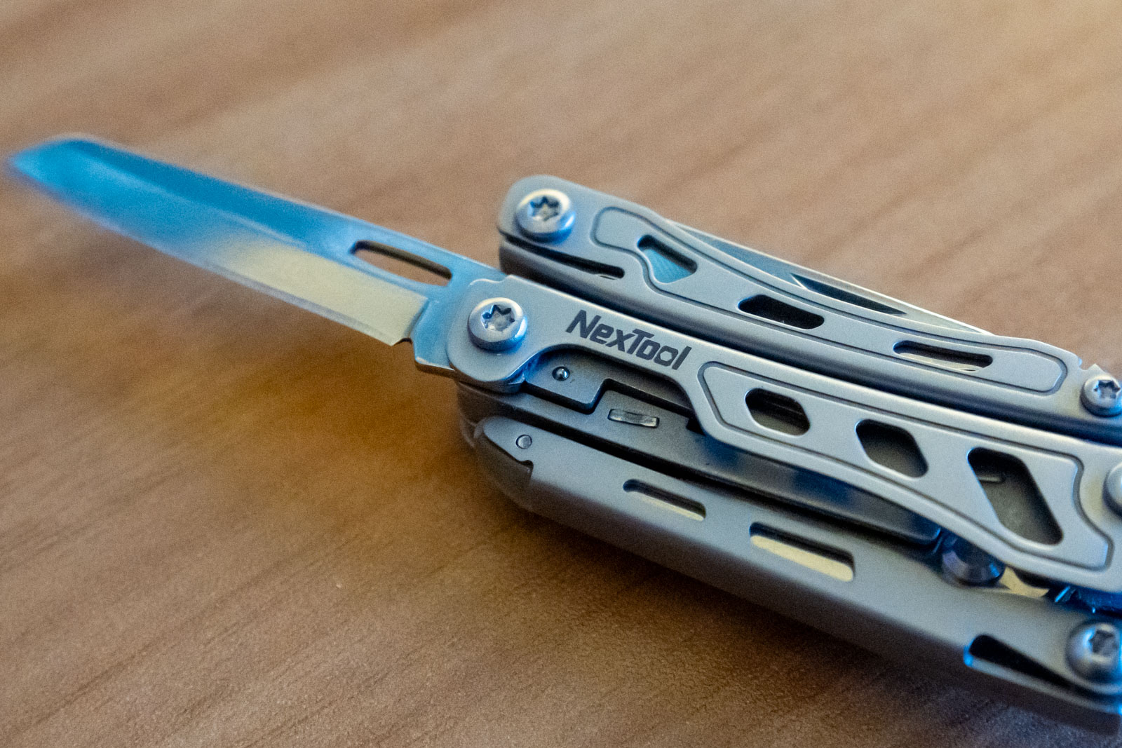 A multi tool on a desk with the knife extended