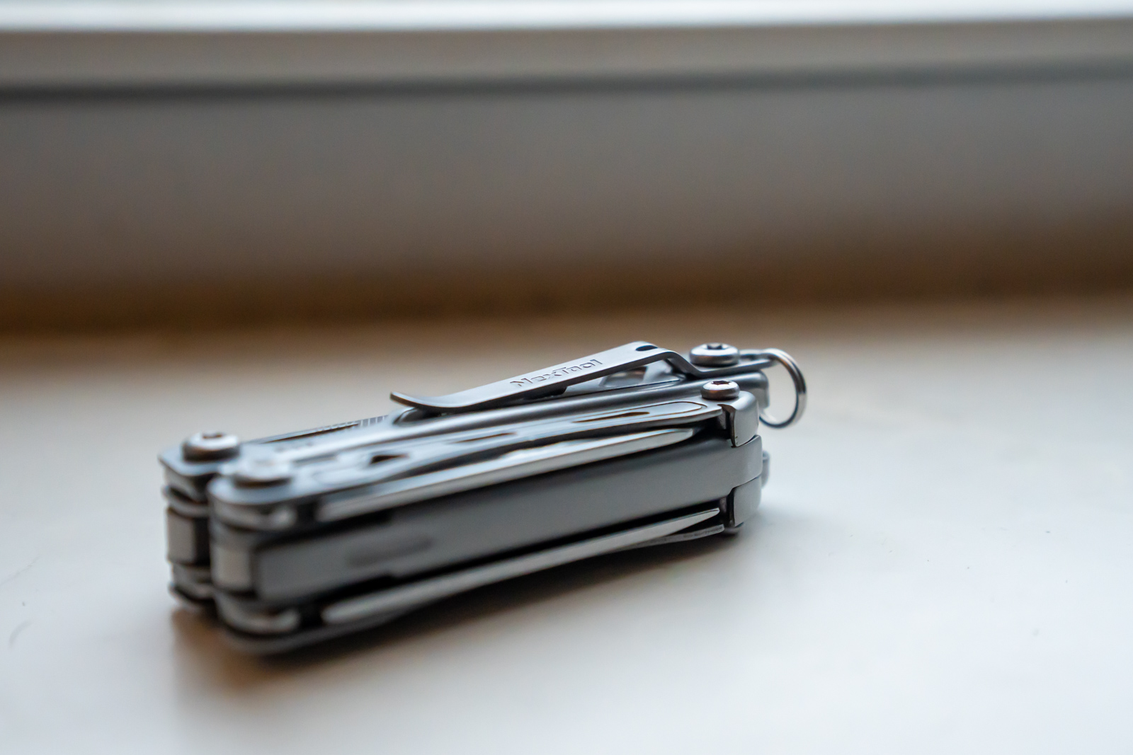 A folded multi tool sits on a desk