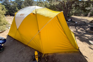 Side view of the Base Camp 6 tent's vestibule fully deployed with the rainfly extended over the front entry.