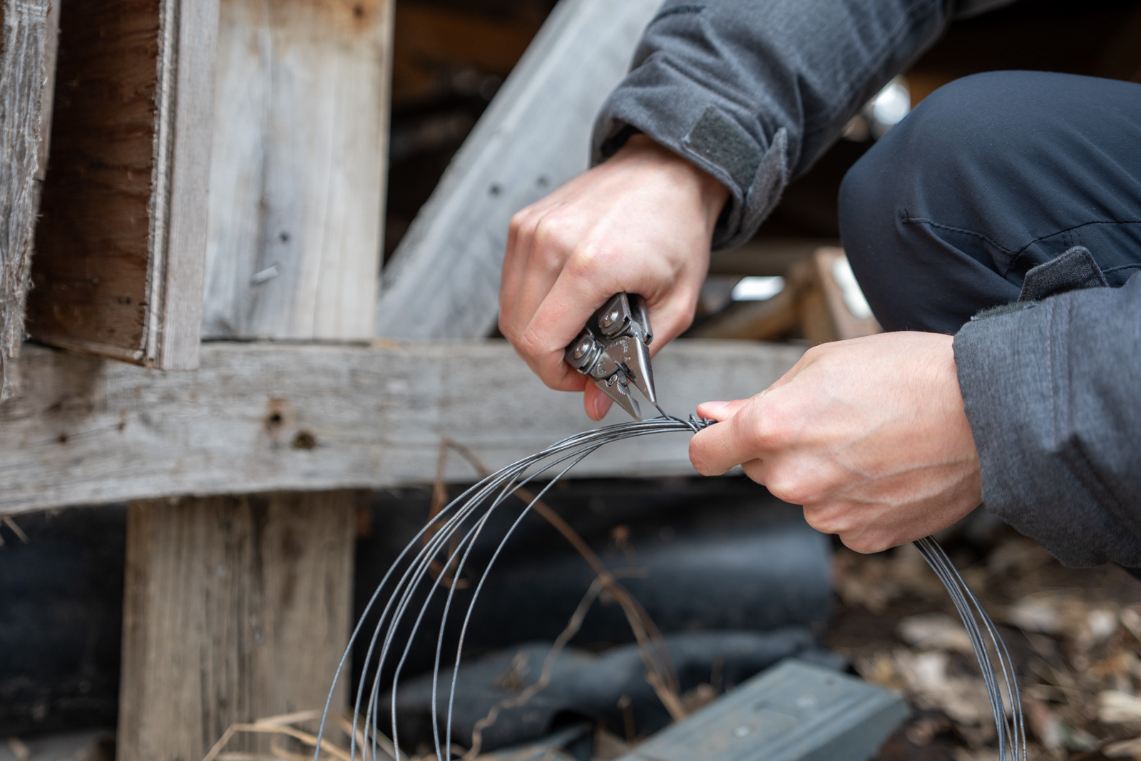 A man uses a multi tool players to cut wire