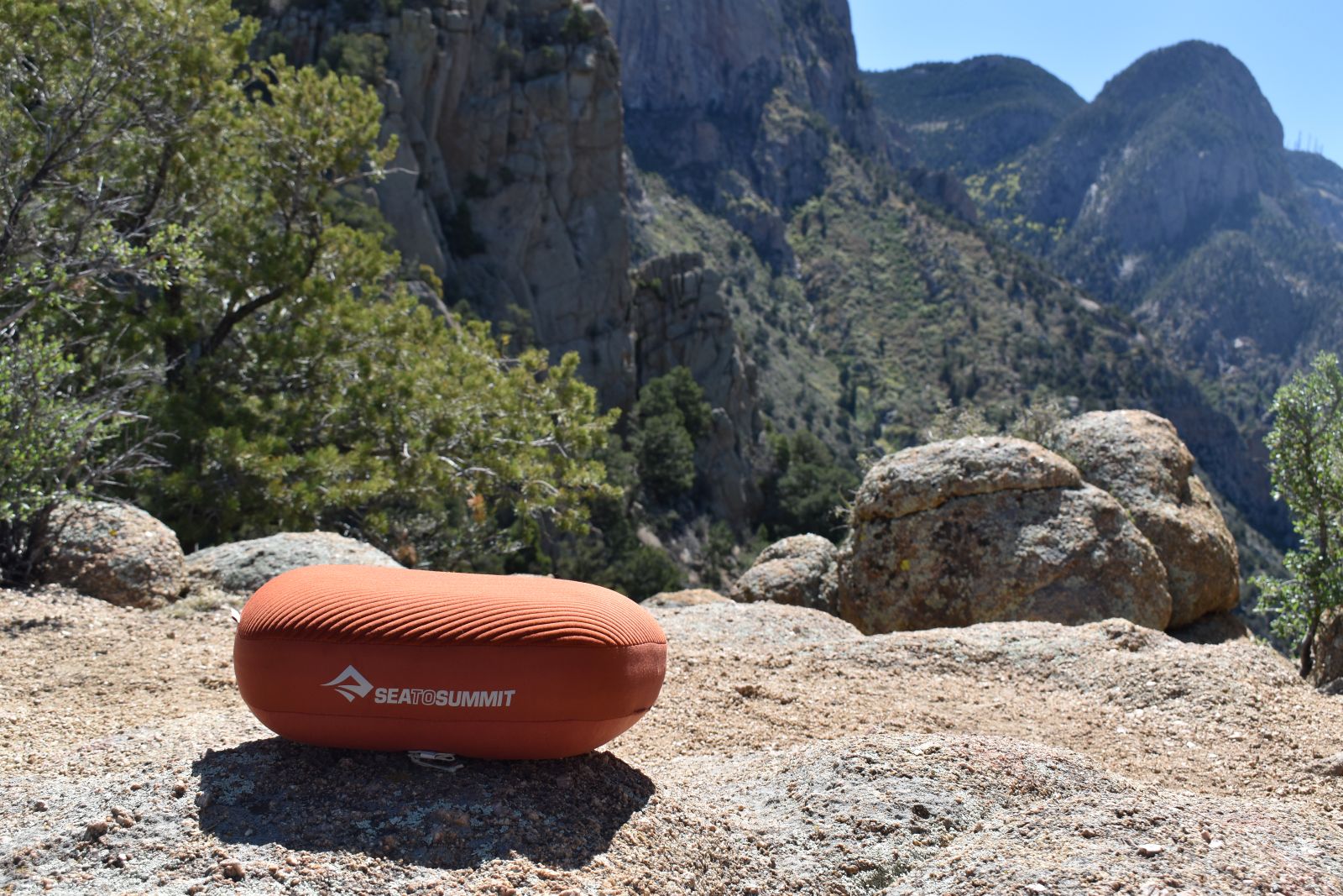 Wide shot of the Sea to Summit Aeros Premium Pillow sitting on a rocky ledge overlooking a canyon.