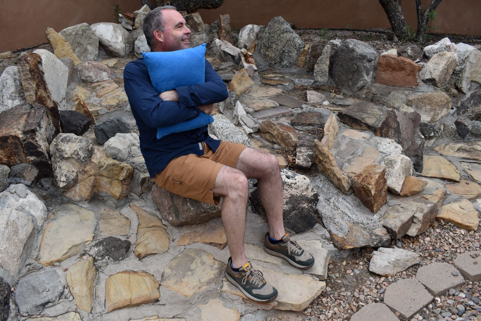 A hiker hugs the Wise Owl Snoozy pillow.