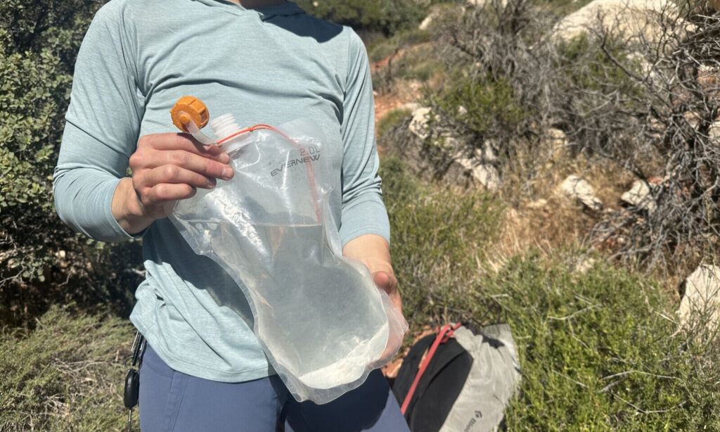 Close up of a hiker holding a lightweight hydration bladder.