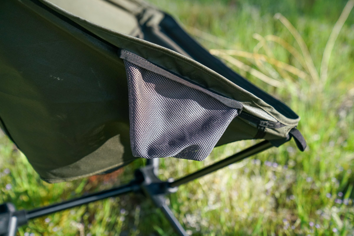 A close up of a cup holder on a scoop-seat camping chair.