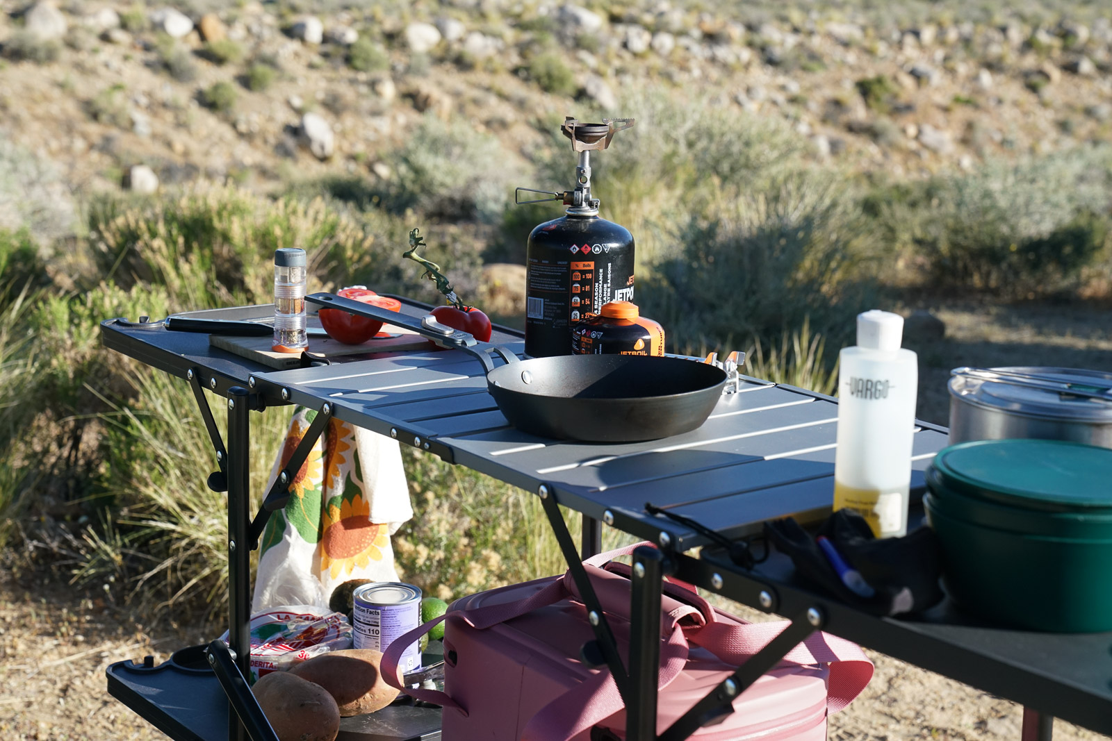 A close up of the top of a cook station. Various cooking items rest on the surface.