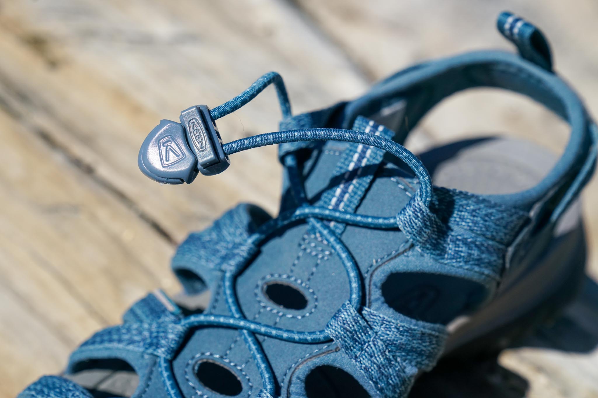 A close up of the toggle on the bungee lace of a sandal.