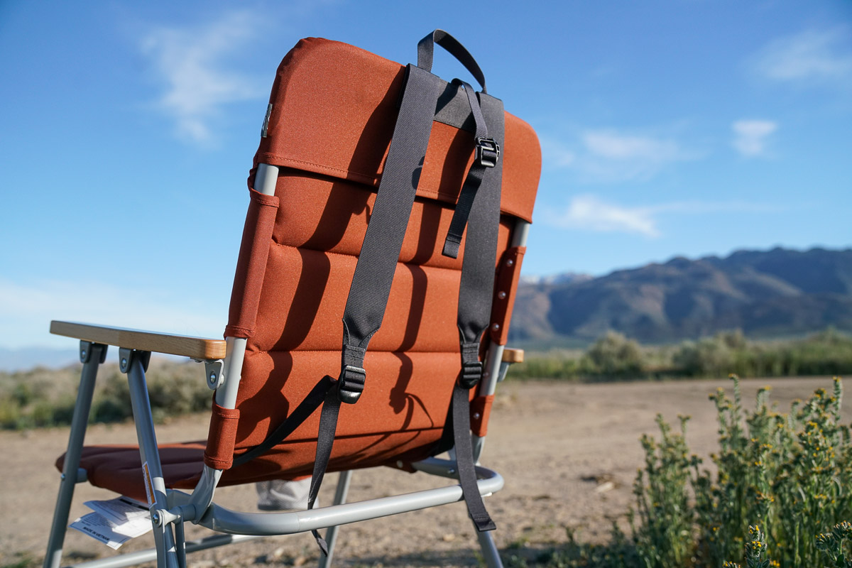 A close up of the backpack straps on the back of a folding camping chair.
