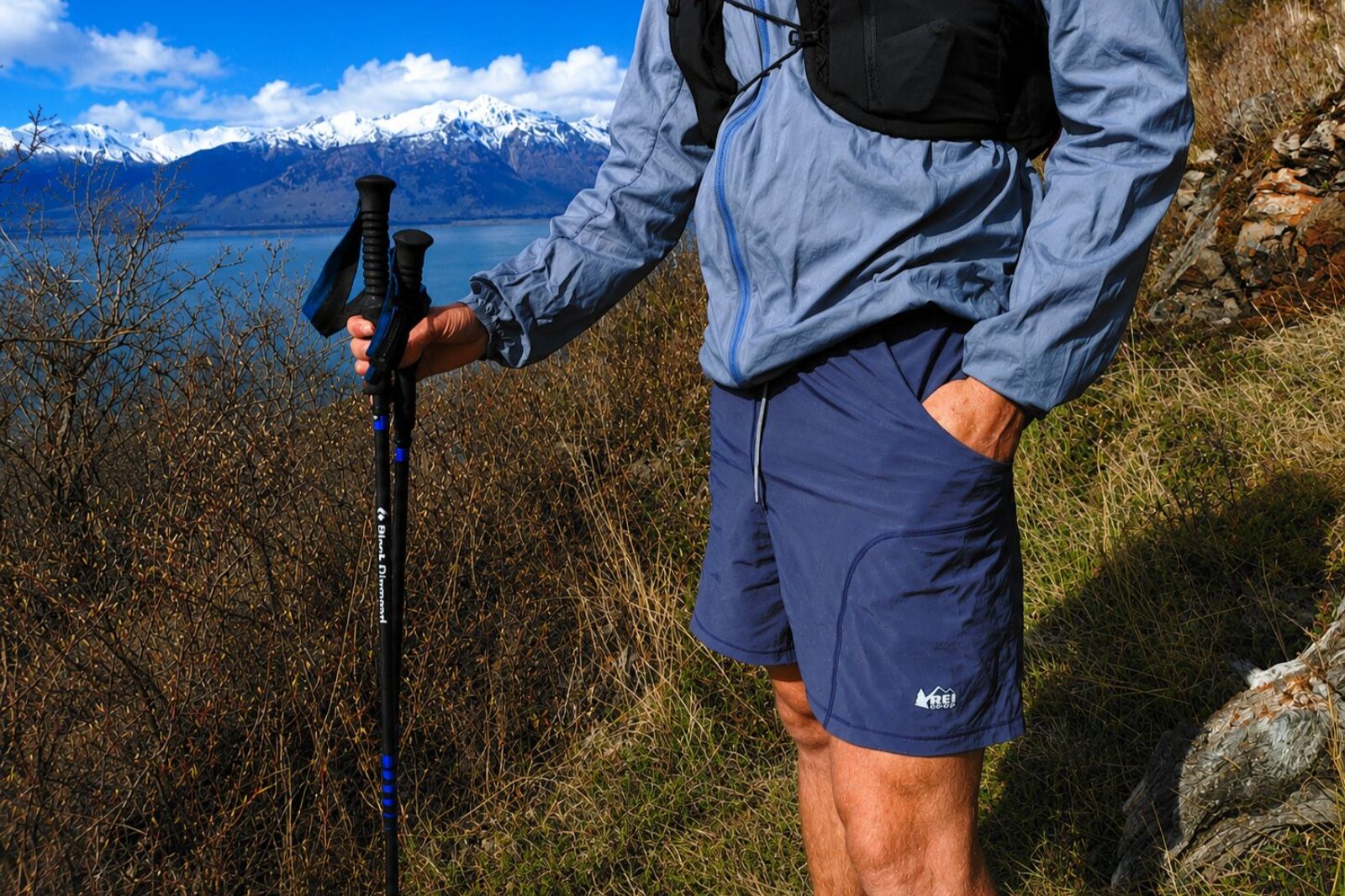 A closeup of blue shorts with a person with their hands in their pockets.