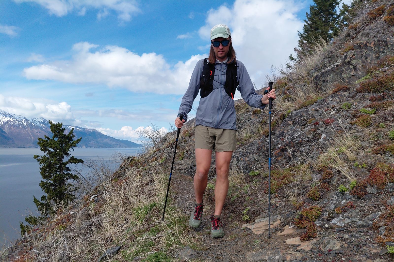 A man walks down a trail wearing brown shorts.