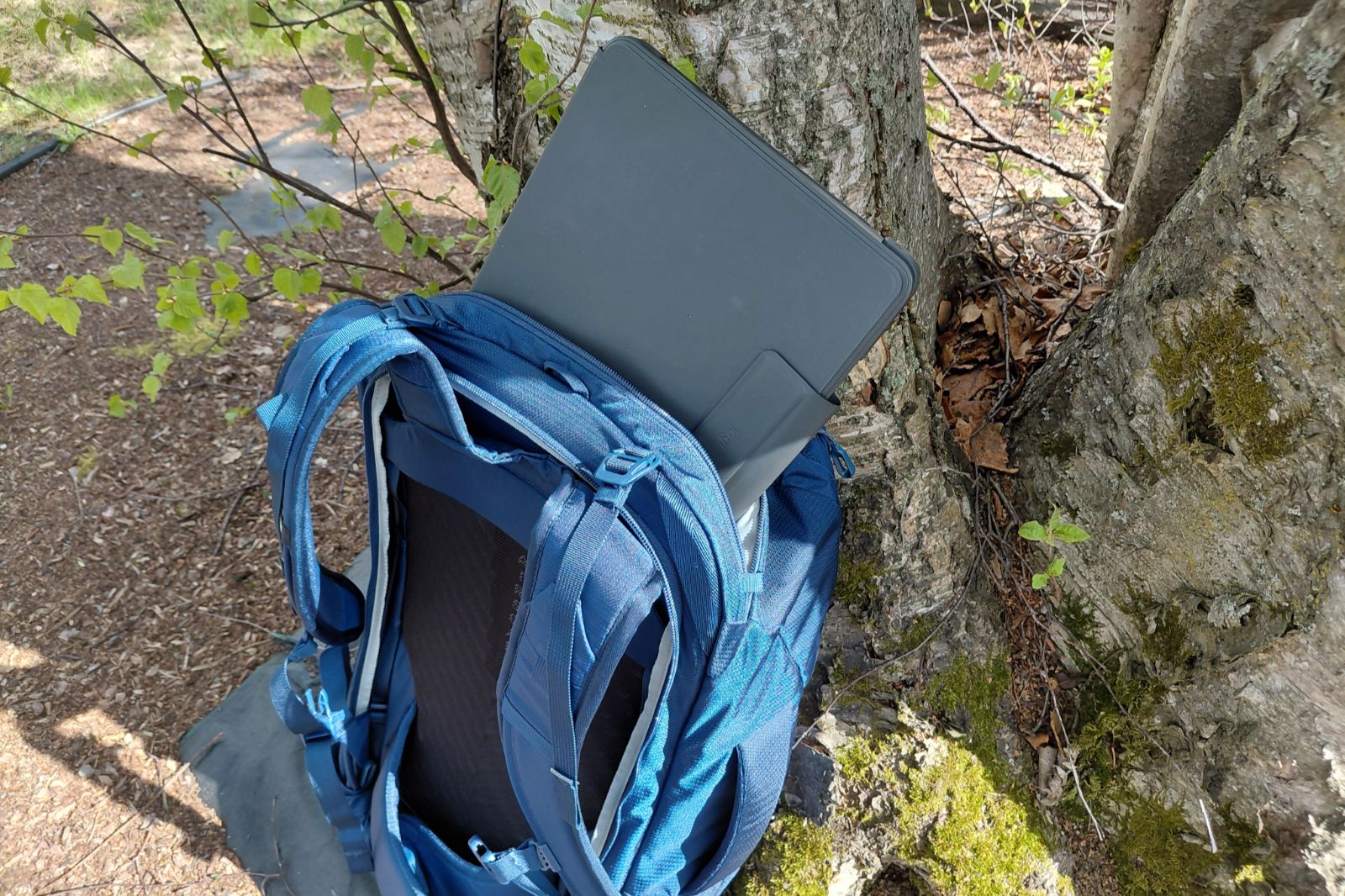 laptop being slid into osprey farpoint travel backpack