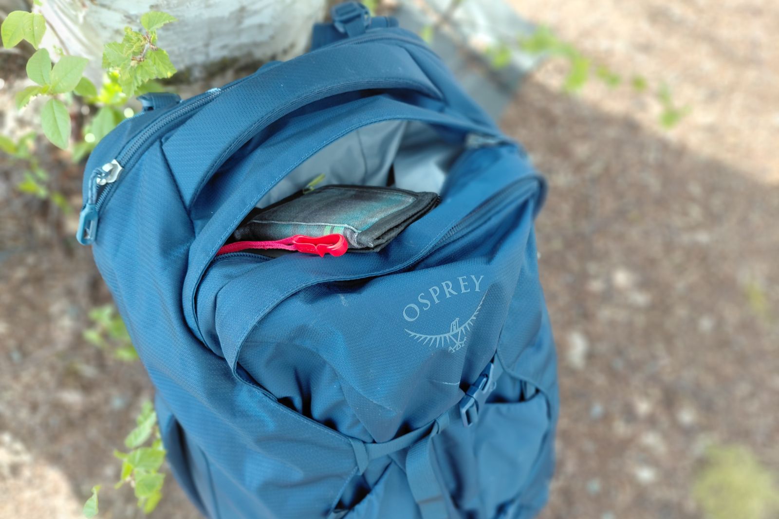 travel backpack on the ground with small valuables pocket unzipped