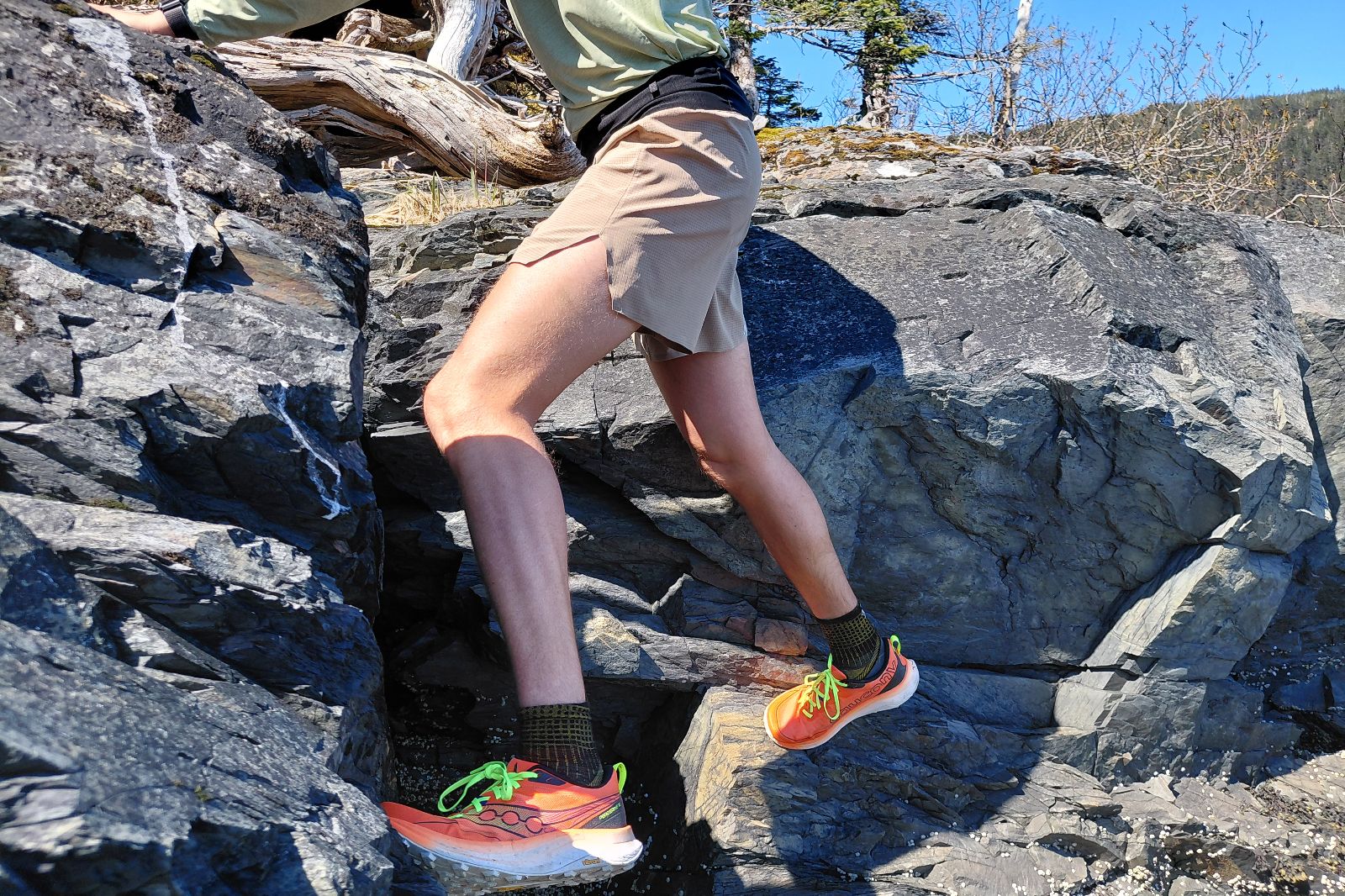 A person climbs down a rocky outcropping.