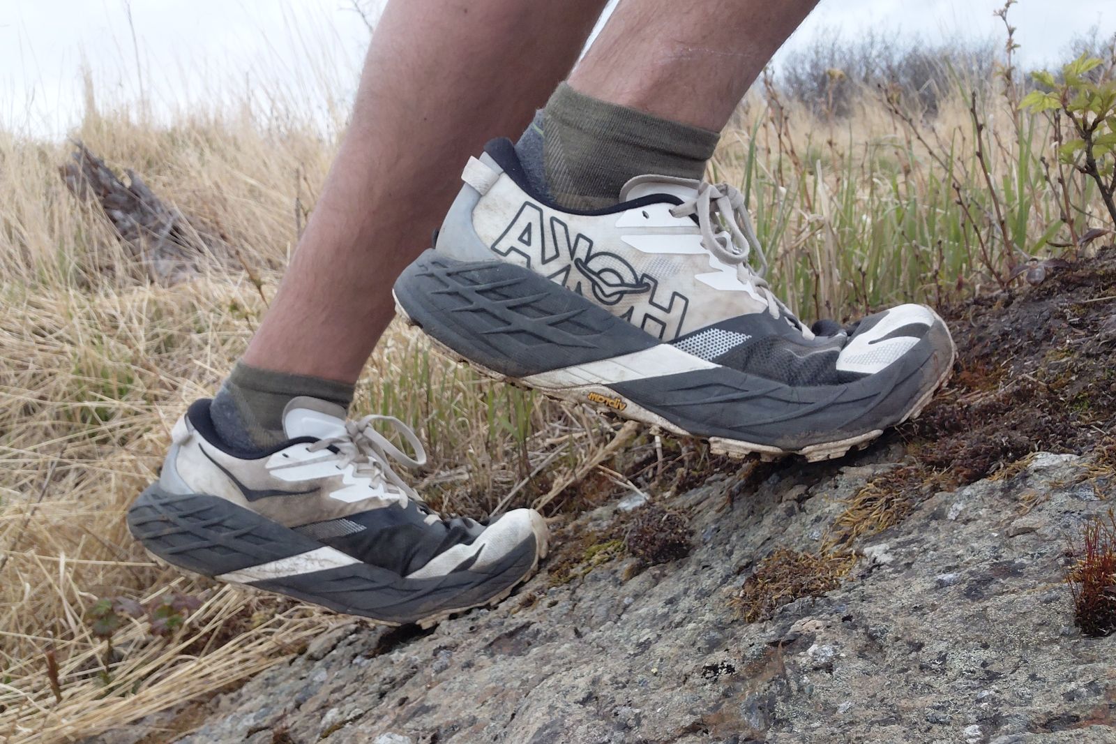 Closeup of a pair of shoes climing up a rock.