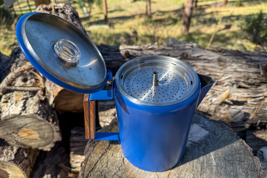 Close-up image of a coffee percolator with the perforated basket and stem assembly visible inside the pot.