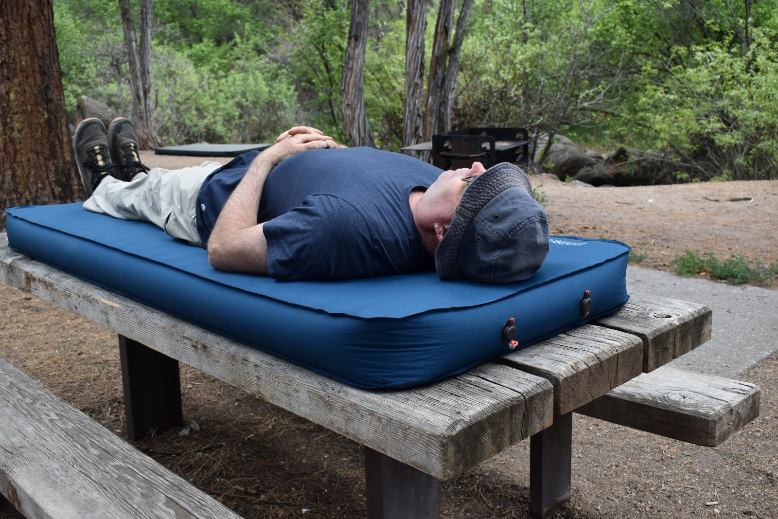 Our testers rests on a blue Big Agnes camping mattress after it self-inflated