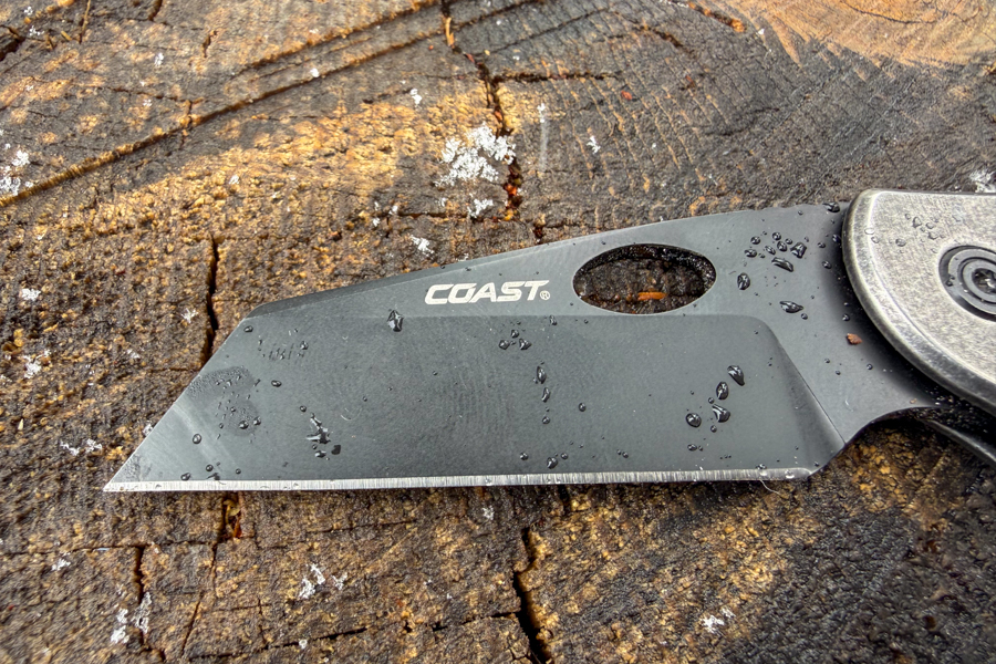 Close-up of the Coast Contra black-coated blade with water droplets on the edge and flat of the blade.
