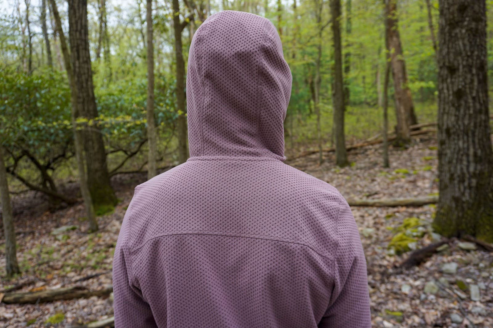Woman faces away from camera while wearing fleece with hood up