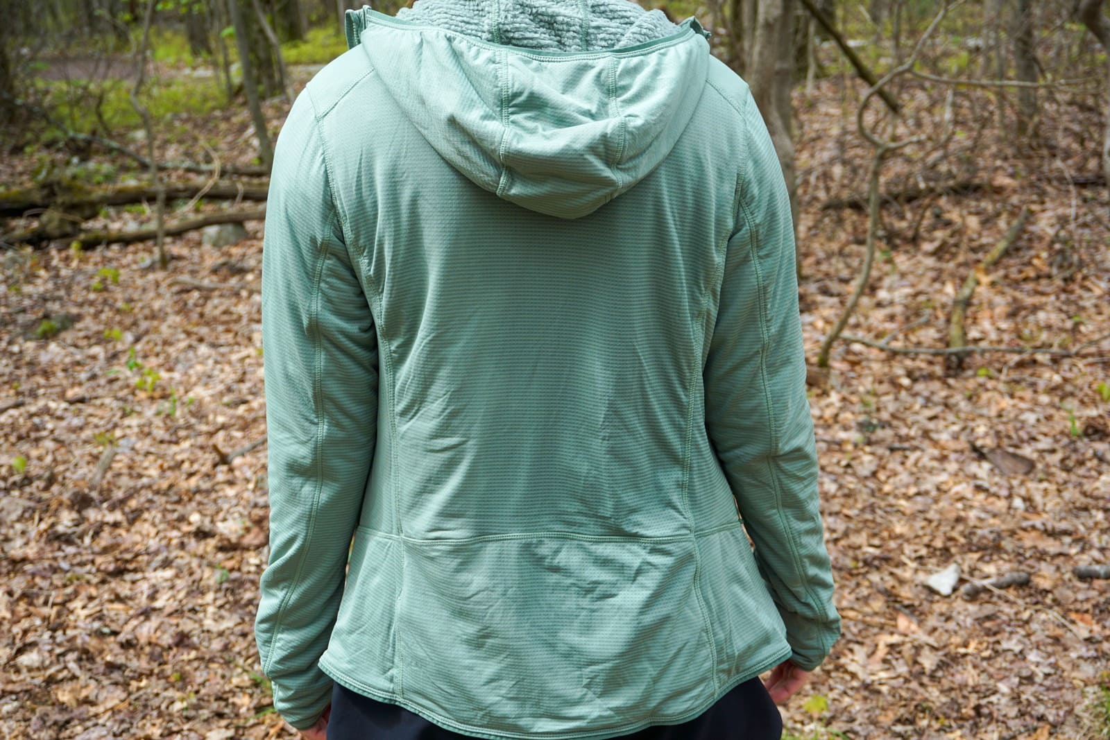 Woman faces away from camera while wearing a hooded jacket
