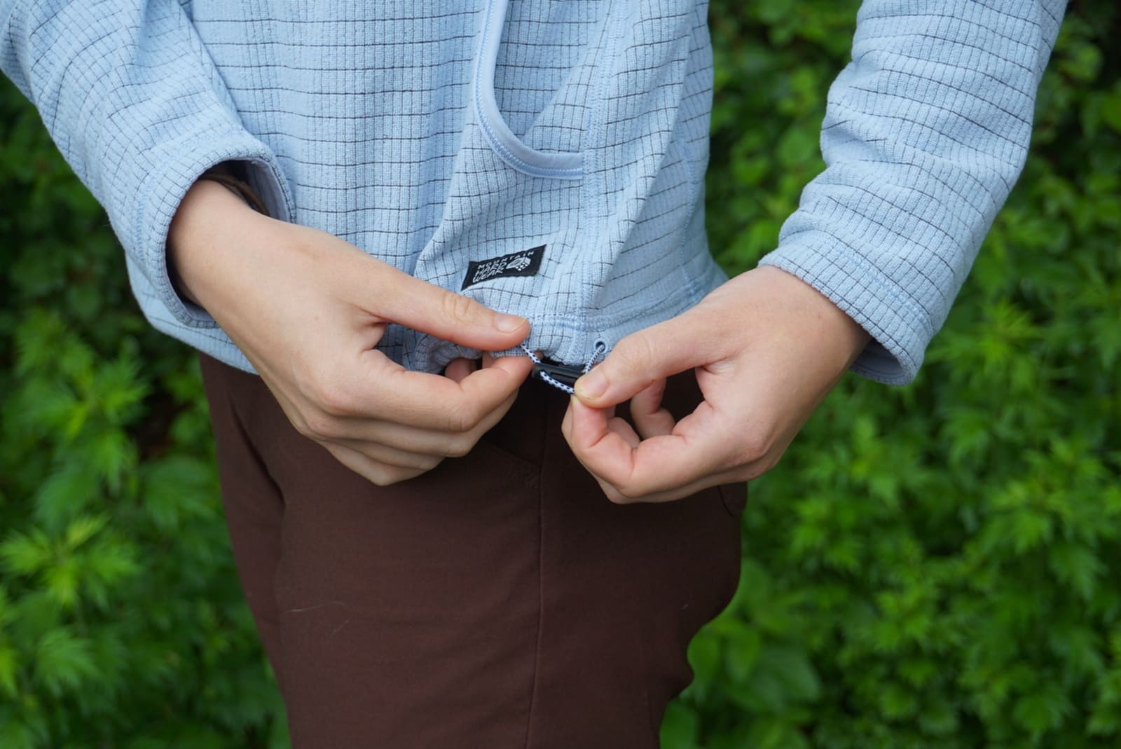 Woman tightens elastic around hemline of jacket