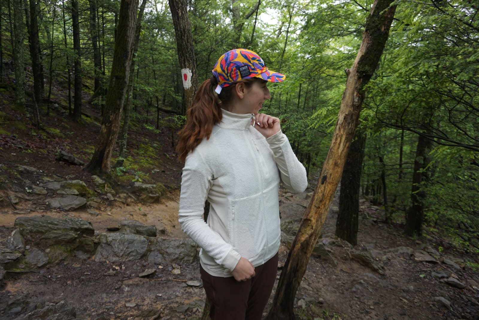 Woman shows neck collar on fully-zipped jacket