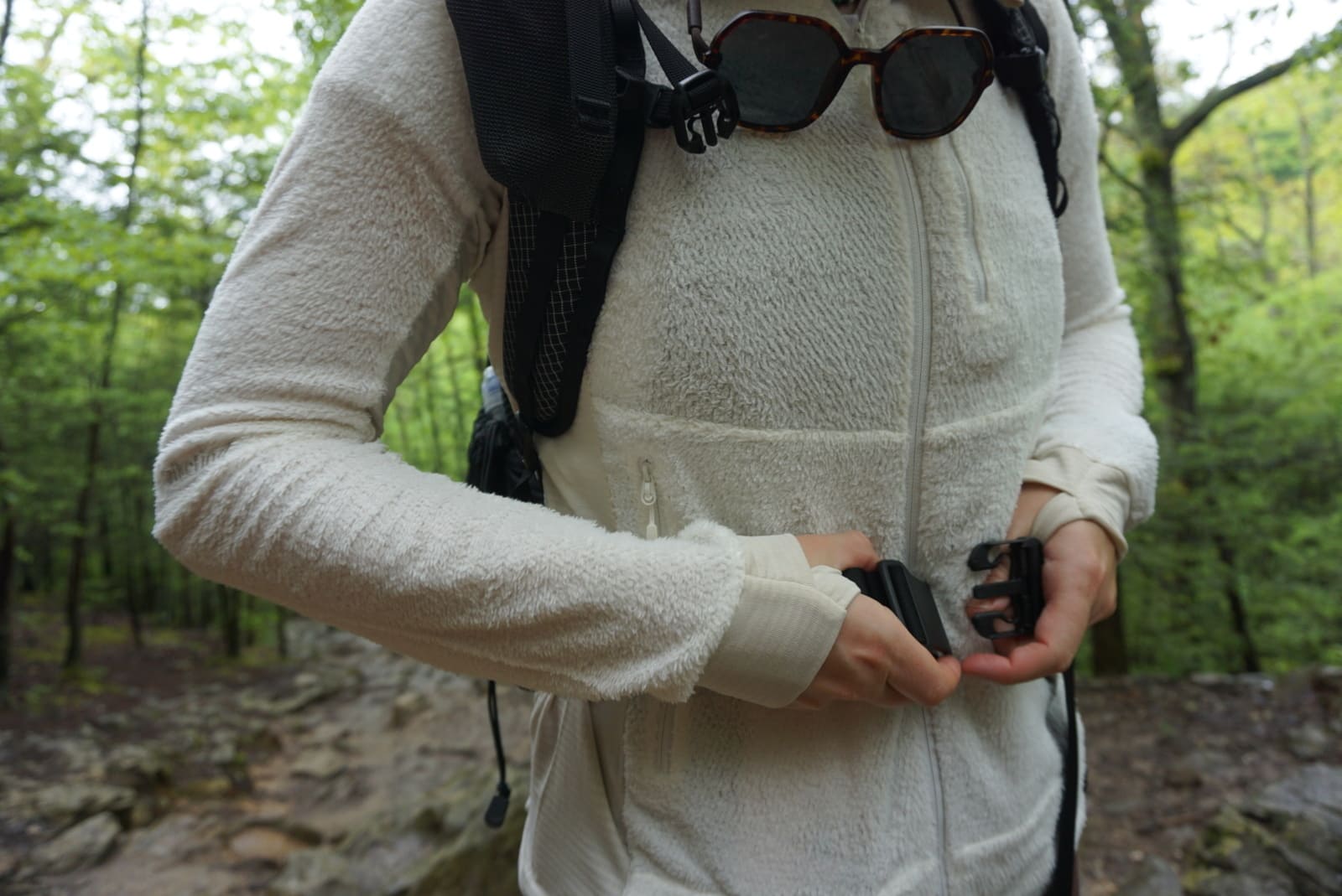 Woman buckles hip belt over white jacket