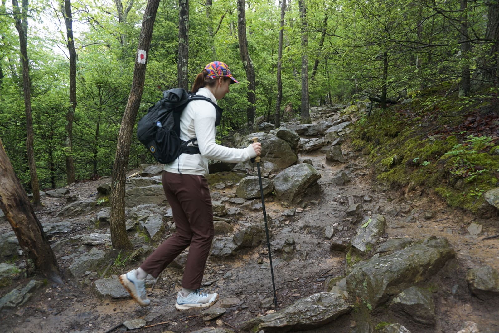 A woman walks uphill in a white jacket