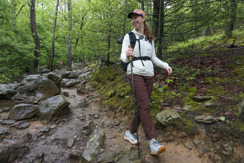 Woman walks down a trail in a white jacket